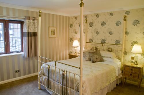 a bedroom with a canopy bed and two lamps at Albright Hussey Manor in Shrewsbury