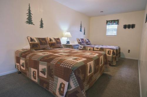 two beds in a room with trees on the wall at Alpine Lodge Resort in Branson