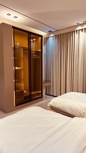a bedroom with a bed and a large window at شقة غادة الفندقية الفاخرة in Abha