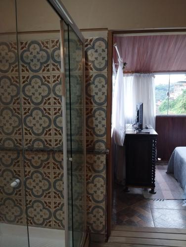 a bedroom with a glass door leading to a bed at Pousada Villa Provence in Petrópolis