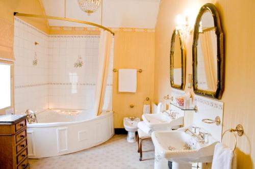 a bathroom with a tub and two sinks and a bath tub at Albright Hussey Manor in Shrewsbury
