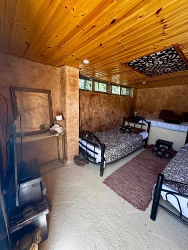 a room with two beds and a tv in it at Oak Farm مزرعة الملّول in Ajloun