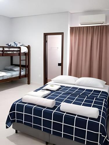 a blue and white bed in a bedroom at Loft 2 com Ar e Garagem até 6 Pessoas Rede Urbana in Indaiatuba
