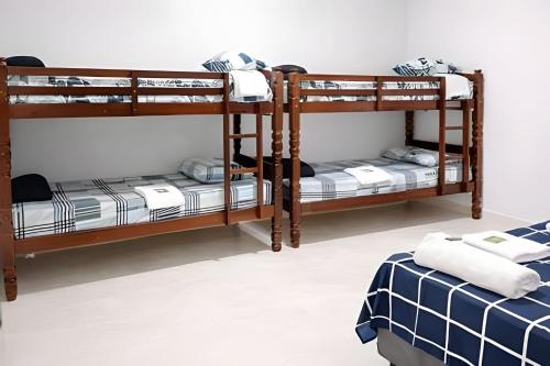 two bunk beds in a room with a bed at Loft 2 com Ar e Garagem até 6 Pessoas Rede Urbana in Indaiatuba