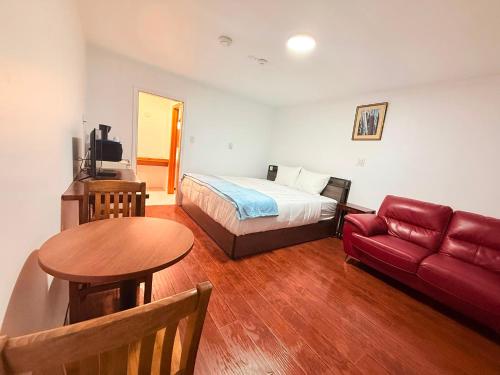a bedroom with a bed and a table and a couch at Sackville Inn in Sackville