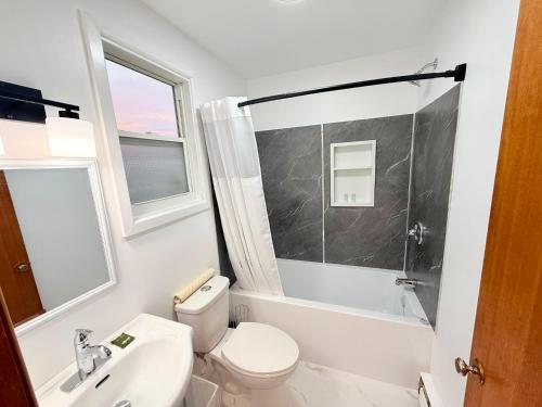 a white bathroom with a toilet and a sink at Sackville Inn in Sackville
