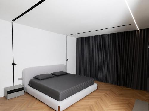 a bedroom with a white bed and a black wall at Hilltop Villa Tirana in Mjull-Bethore