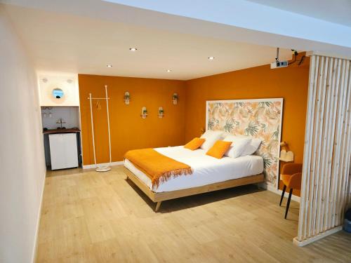 a bedroom with a large bed with orange walls at La Parenthèse du Buisson Bailly - Jacuzzi, Détente et Bien être près de Provins in Choisy-en-Brie