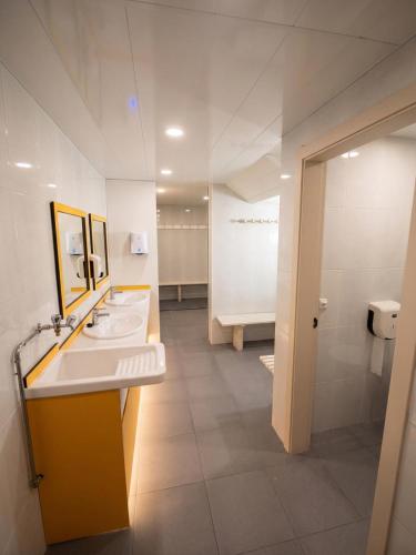 a bathroom with two sinks and a large mirror at As Baladas Hostel in Barro