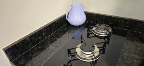a kitchen counter with two burners and a vase at Loft 3 com ar-condicionado da Rede Urbana in Indaiatuba