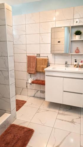 a white bathroom with a sink and a shower at Coeur A 2 in Macouria