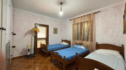 a bedroom with two beds and a mirror at Gioele apartament in Vlorë