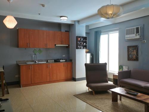 a kitchen with a couch and a chair in a room at Apartment with Kitchen Walking Distance to Station Two in Boracay