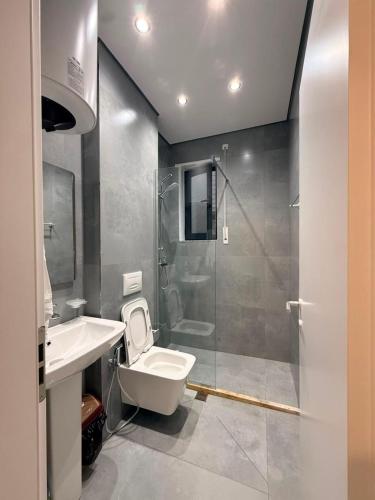a bathroom with a toilet and a sink and a shower at Coastal Pine Appartment in Golem