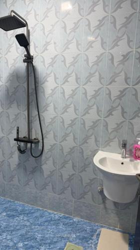 a bathroom with a shower and a sink at Cozy rooms in Mirbāţ