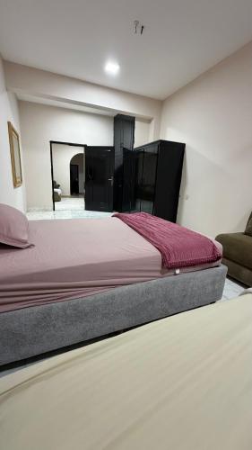 a bedroom with a bed and a couch at Cozy rooms in Mirbāţ