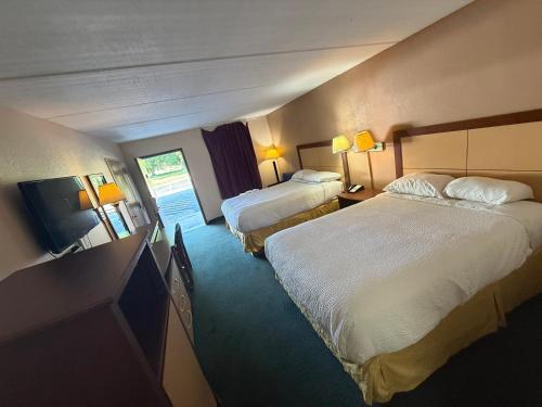 a hotel room with two beds and a television at Camilla Inn & Suites in Camilla