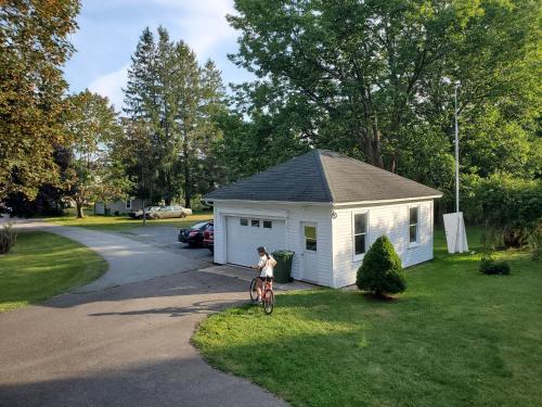 a woman riding a bike in front of a small house at The Kinley House in Lunenburg