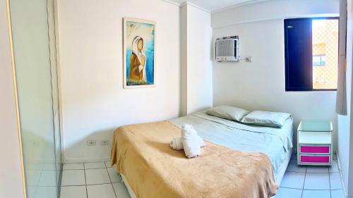 a small bedroom with a bed and a painting at Vacanze - Neo in Maceió