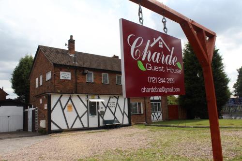 a sign in front of a building with a house at Charde Guest House in Birmingham