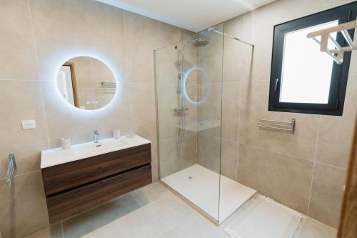 a bathroom with a sink and a shower with a mirror at Villa Ezilia in Alata