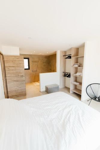 a bedroom with a white bed and a closet at Villa Ezilia in Alata