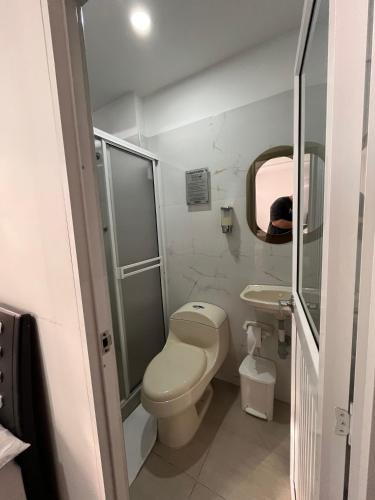 a small bathroom with a toilet and a sink at Euros Hotel in El Bordo