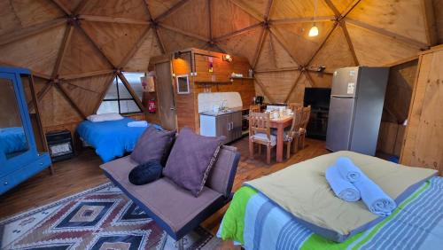 a room with two beds and a kitchen in a yurt at Oceana Suites Refugio de Maipo in San José de Maipo