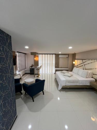 a bedroom with a large bed and a living room at Euros Hotel in El Bordo