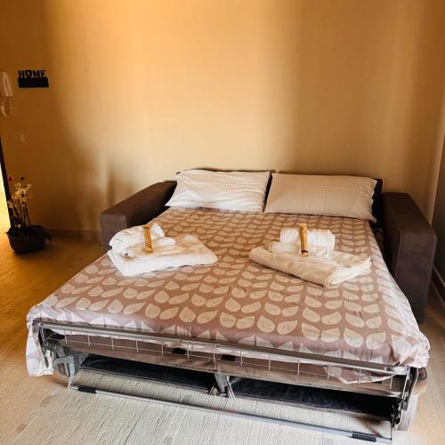 a bed with two towels on it in a bedroom at Aura Apartment in Senorbì
