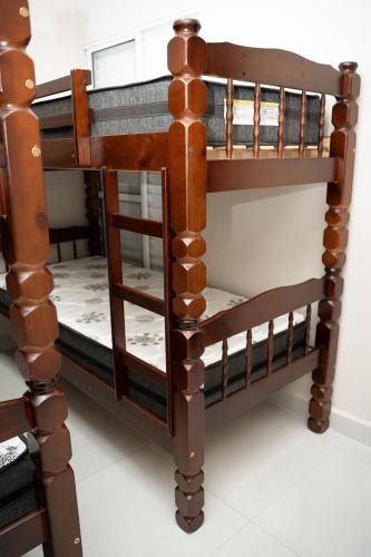 a wooden bunk bed with the top leveled at Casa 2 Quartos com Ar até 8 Pessoas Jd. Sabiás in Indaiatuba