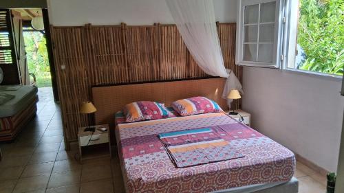 a bedroom with a bed and a window at Kay Zanndoli in La Trinité