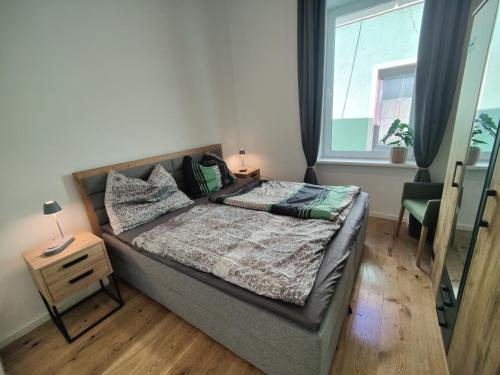 a bedroom with a bed with a night stand and a window at Apartment Felicitas FEE in Tulln