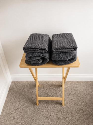 a pile of grey towels sitting on a wooden table at Waterford Triangle Apartment in Waterford