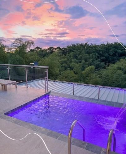 a swimming pool on top of a house with purple lighting at Finca Hotel la Manuela in Armenia