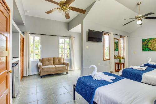 a bedroom with two beds and a chair and a ceiling fan at Hill Garden Boutique Resort in San Ignacio