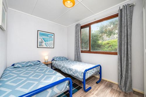 two beds in a room with a window at Blue View - Ocean Views For Miles in Guilderton