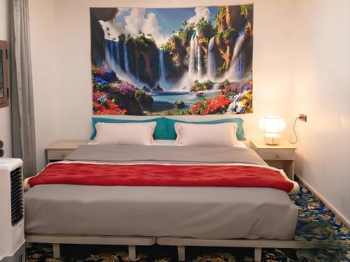 a bedroom with a painting on the wall above a bed at Aziz House 1 Tan Tan in Tan-Tan