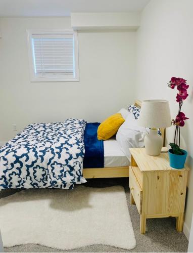 ein Schlafzimmer mit einem Bett und einem Tisch mit einer Lampe in der Unterkunft New Cosy bright and Spacious Apartment in East Gwillimbury