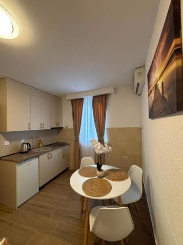 a kitchen with a table and chairs in a room at Aurea Novi 3 in Herceg-Novi