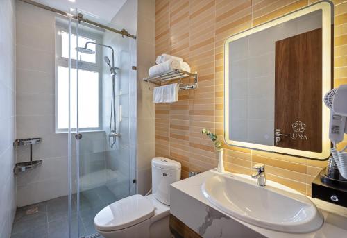 a bathroom with a sink and a toilet and a shower at LUNA Hotel in Vĩnh Long