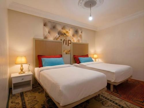 two beds in a room with a football helmet on the wall at Aziz House 2 Tan Tan in Tan-Tan