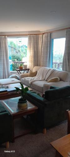 a living room with couches and a couch and a table at Hillview Homestay in Richmond