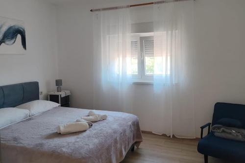 a bedroom with a bed with two towels on it at Apartments by the sea Ugljan - 846 in Ugljan