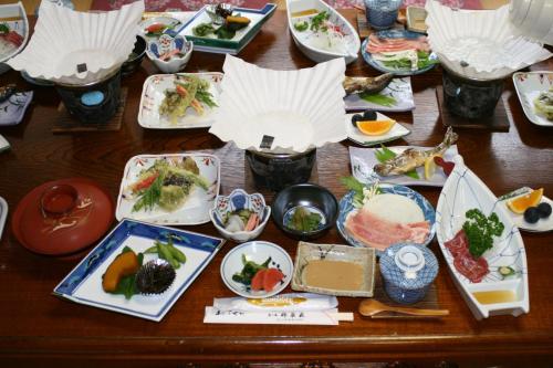 a wooden table with plates of food on it at Suisensou in Takayama