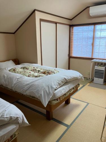 a bedroom with two beds and a window at Nagomi-tei in Hakuba