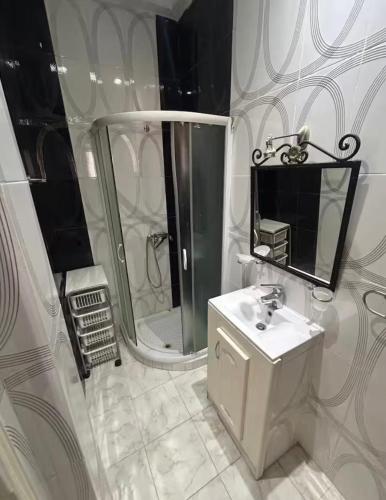 a white bathroom with a sink and a shower at Résidence Djerba Oasis in Mezraya