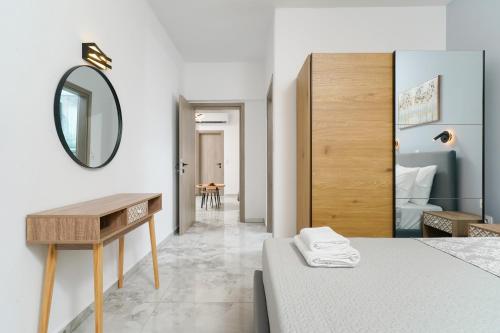 a bedroom with a bed and a mirror and a table at Lumina House Panagia in Panagia