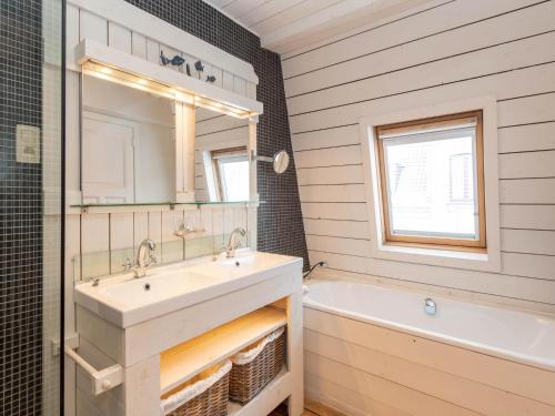 a bathroom with a sink and a tub and a mirror at Tuzzetje in Nieuwpoort