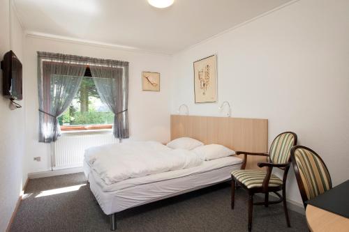 Schlafzimmer mit einem Bett, einem Schreibtisch und einem Stuhl in der Unterkunft Hotel Bov Kro in Padborg